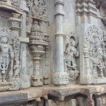 The stone edifice shown is a temple with an incredible amount of carvings on it. There are many deities and details carved into the walls.