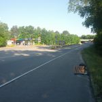 A backpack is sitting in the shoulder of an on-ramp with a cardboard sign reading "NYC". A sign indicates that the on-ramp is Interstate 95.