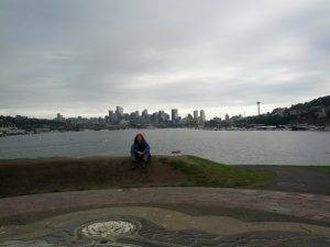 Mikey sits on a hill at Gas Works Park overlooking the PUget Sound and the Seattle Skyline